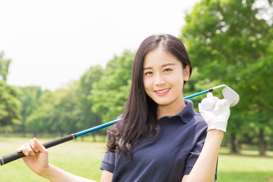ゴルフをプレイする若い女性